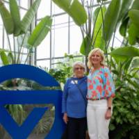 Two party attendees standing by circle G